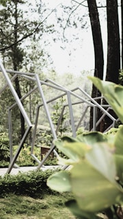 An outdoor view of the exhibition space showing organic bamboo forms blending with greenery.