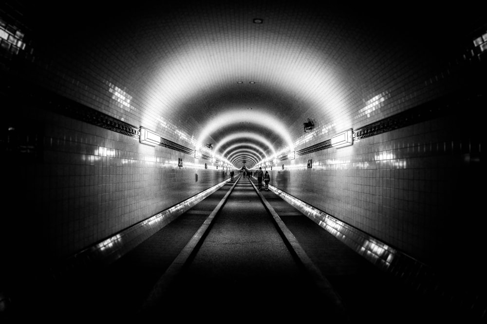 grayscale photo of tunnel with light