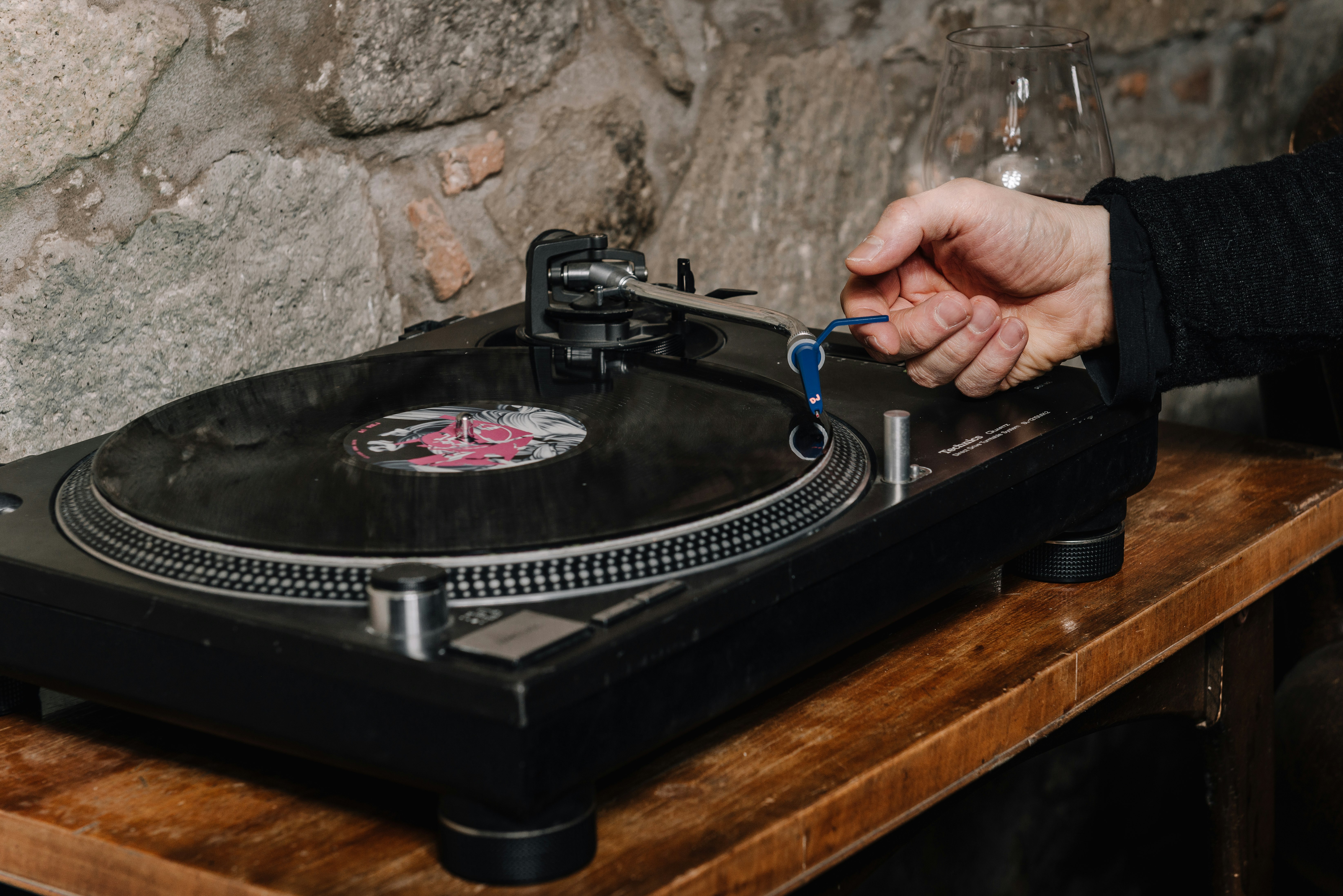 person holding black and silver vinyl record player