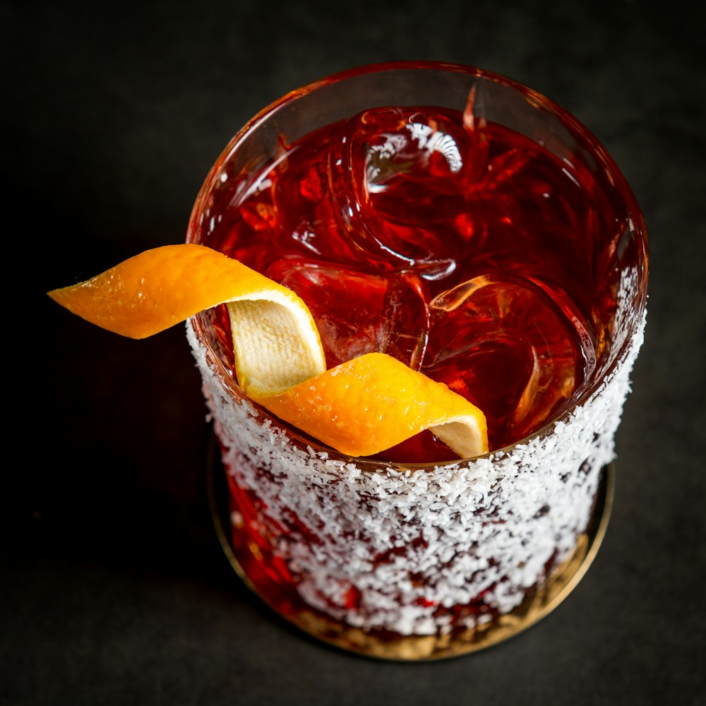 clear drinking glass with red liquid and sliced lemon