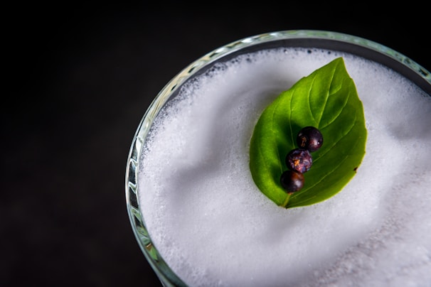 A close-up of a glass of malt drink garnished with dry fruits.