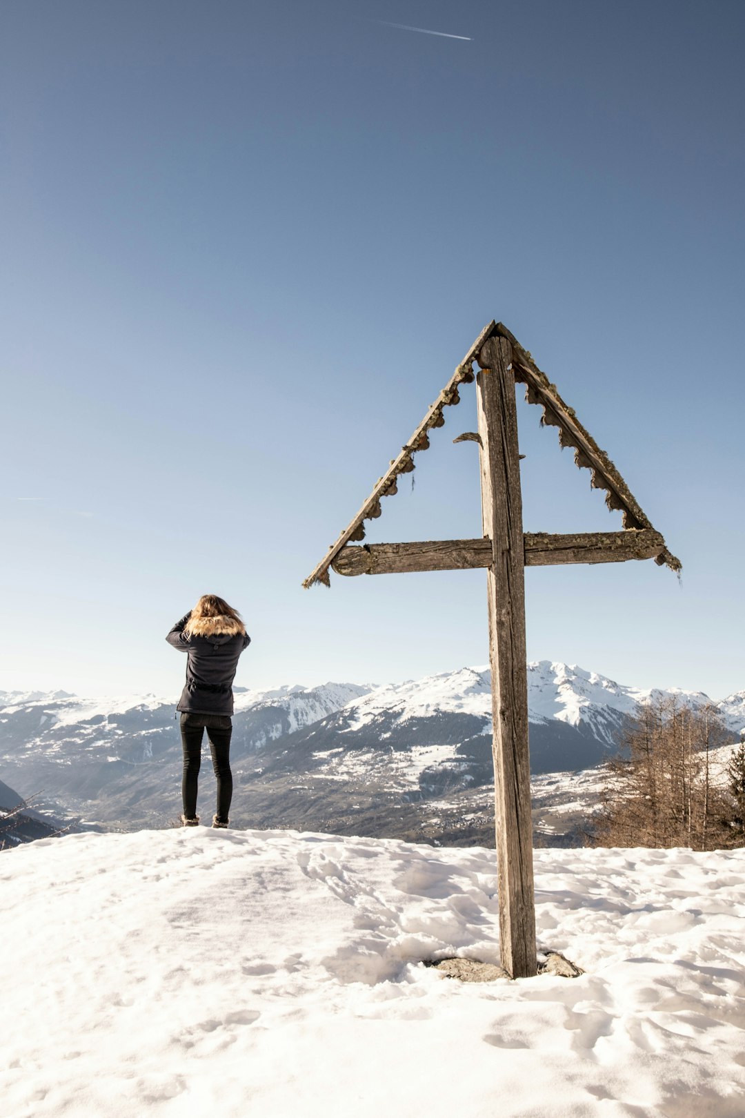 woman in brown jacket standing on snow covered mountain during daytime