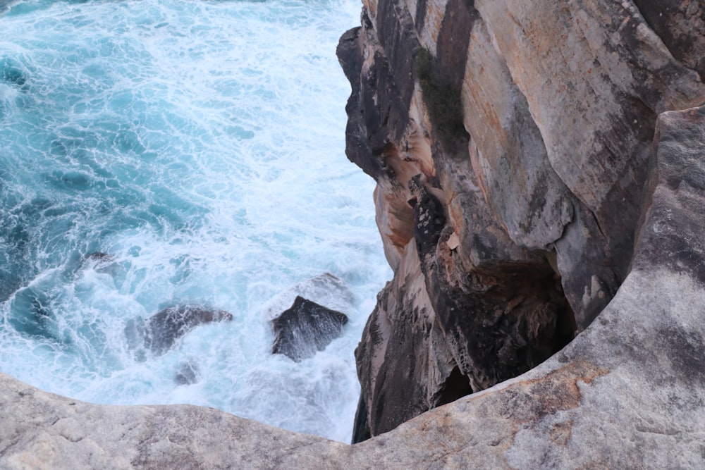 brown rocky mountain beside body of water during daytime