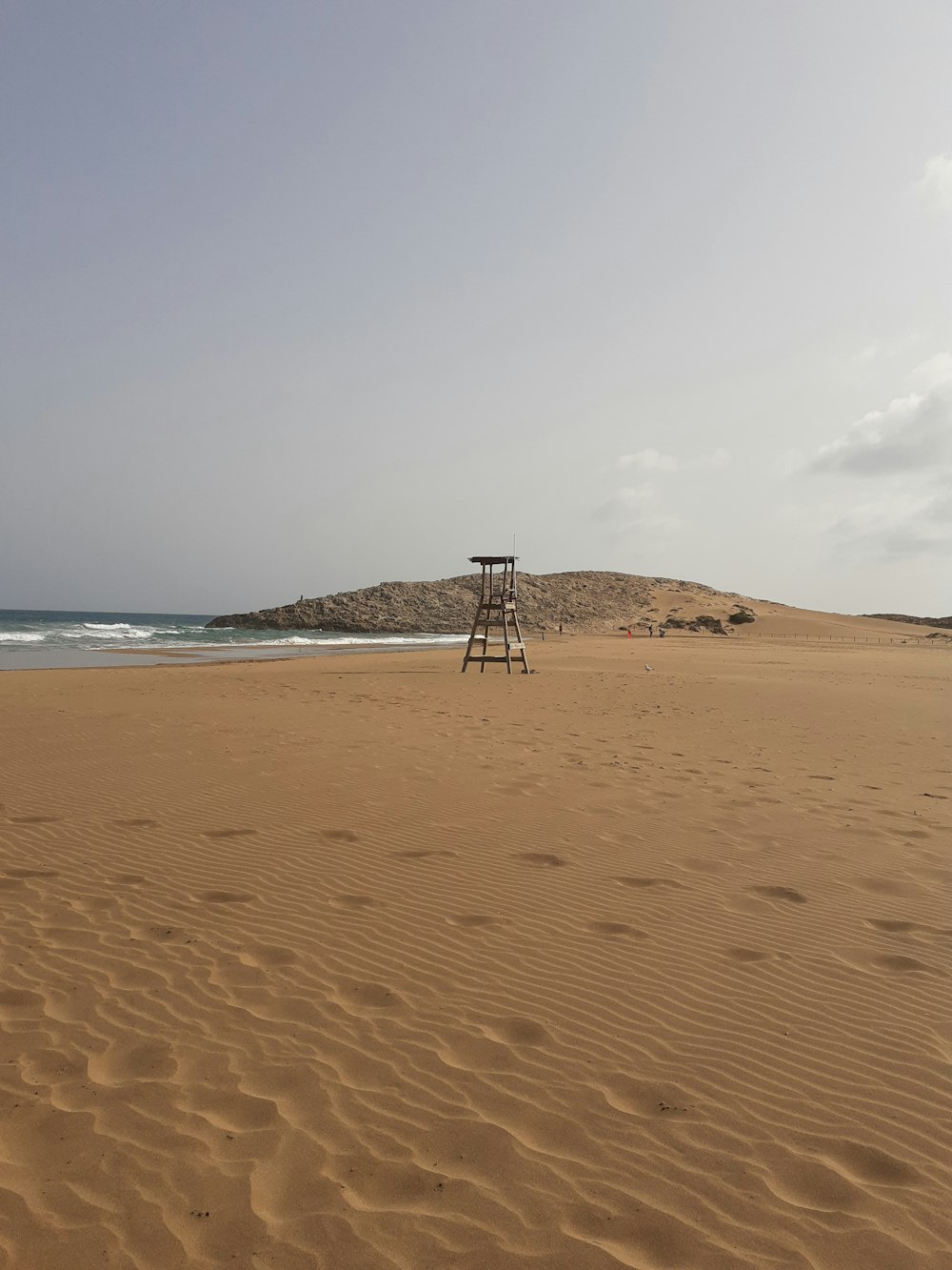 white and black lifeguard chair on beach during daytime