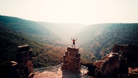 person standing on brown concrete building during daytime