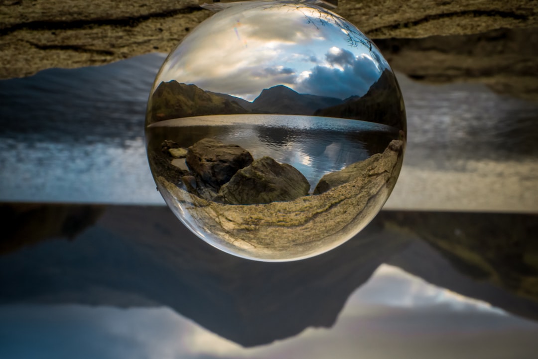 clear glass ball on white sand during daytime