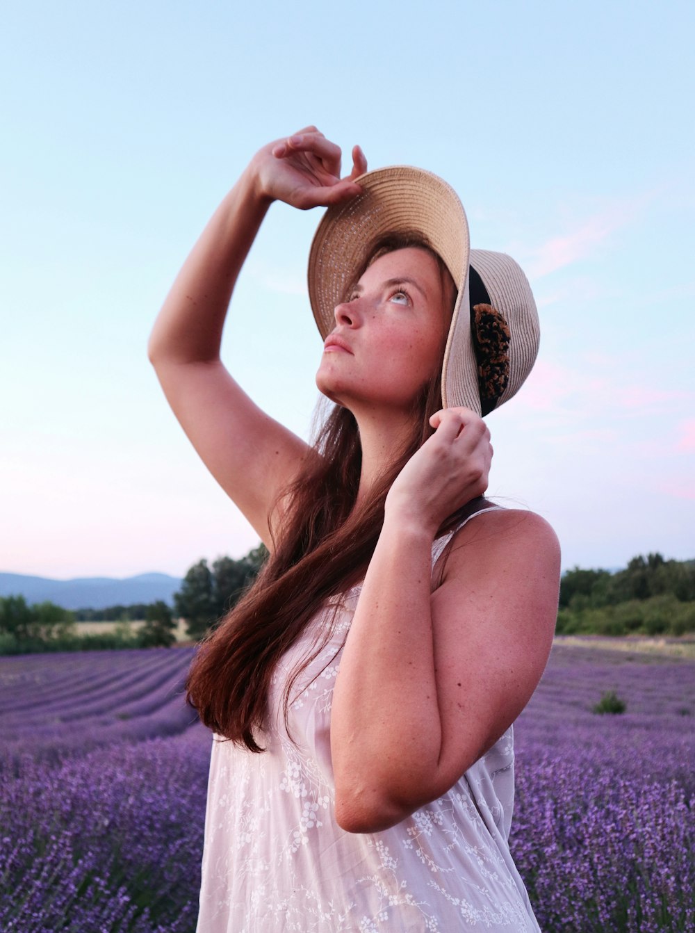 woman in white tank top wearing brown straw hat