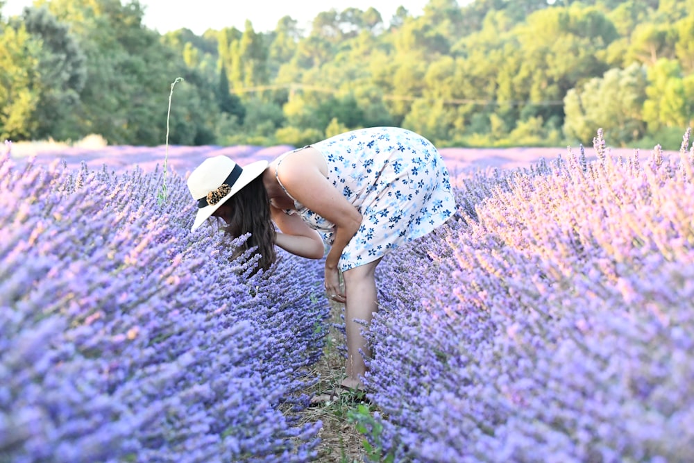 woman in blue and white floral dress standing on purple flower field during daytime