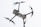 A drone captured in flight against a light sky background. The focus is on the body and propellers, with rotors in motion creating a blur effect. The drone appears sleek and modern, featuring sensors and a camera on the front.