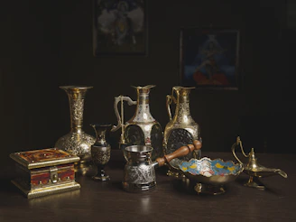 Artfully arranged antique gold ladles and tongs on a pristine white background with subtle shadows.