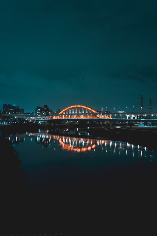 bridge over water during night time in Chengmei Left Bank Riverside Park Taiwan