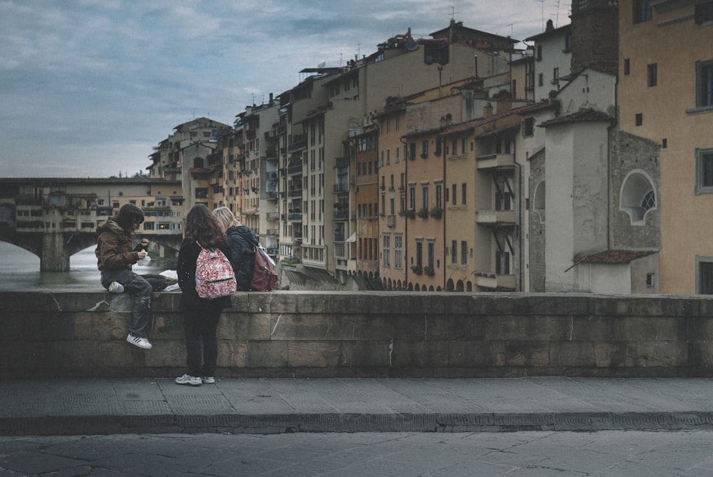 woman in pink and black jacket standing on sidewalk during daytime