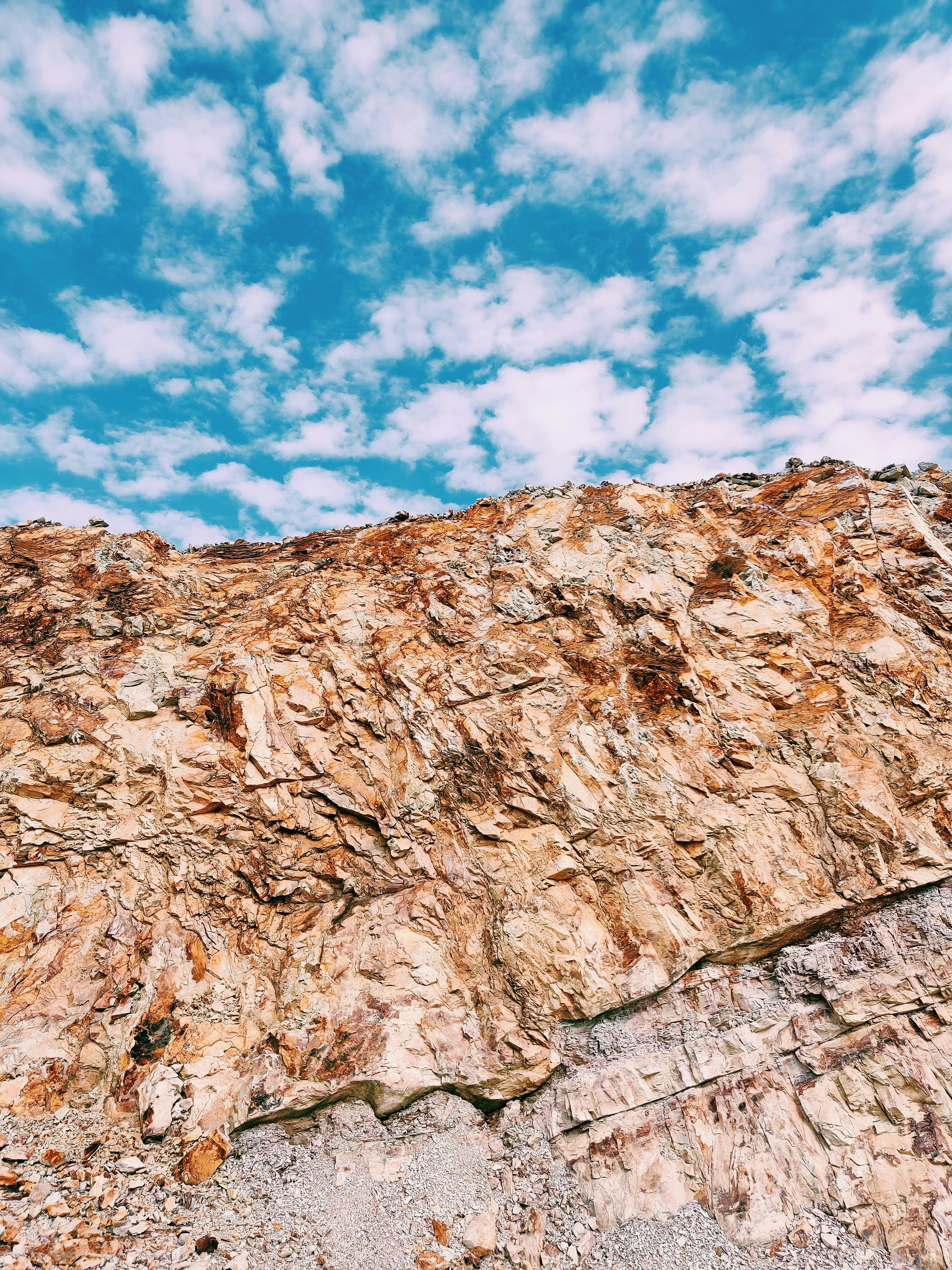 Formación rocosa marrón bajo el cielo azul y nubes blancas durante el día