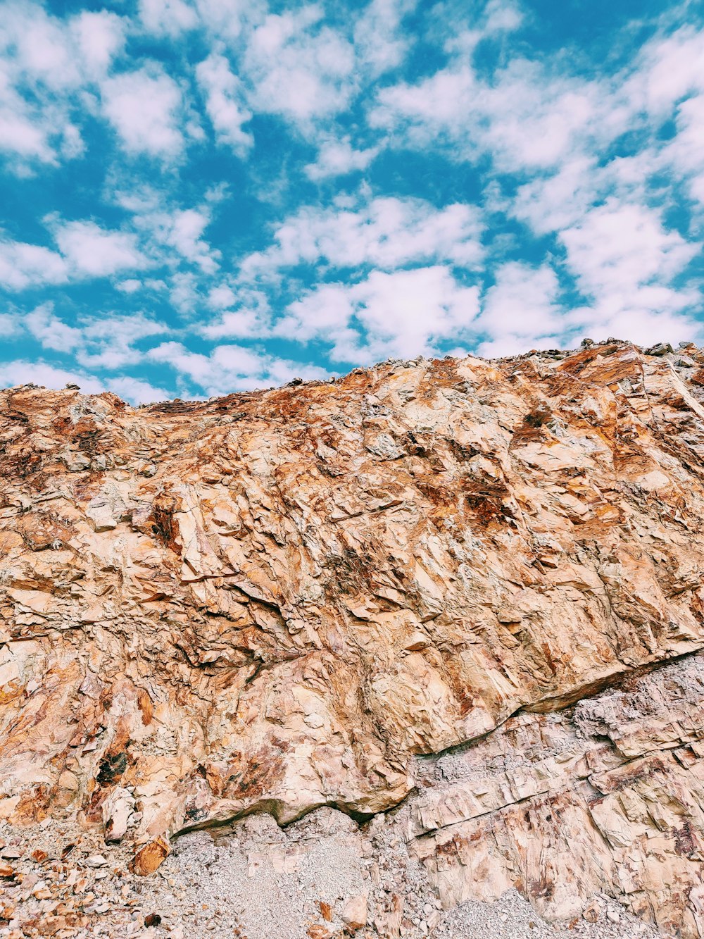 Formación rocosa marrón bajo el cielo azul y nubes blancas durante el día