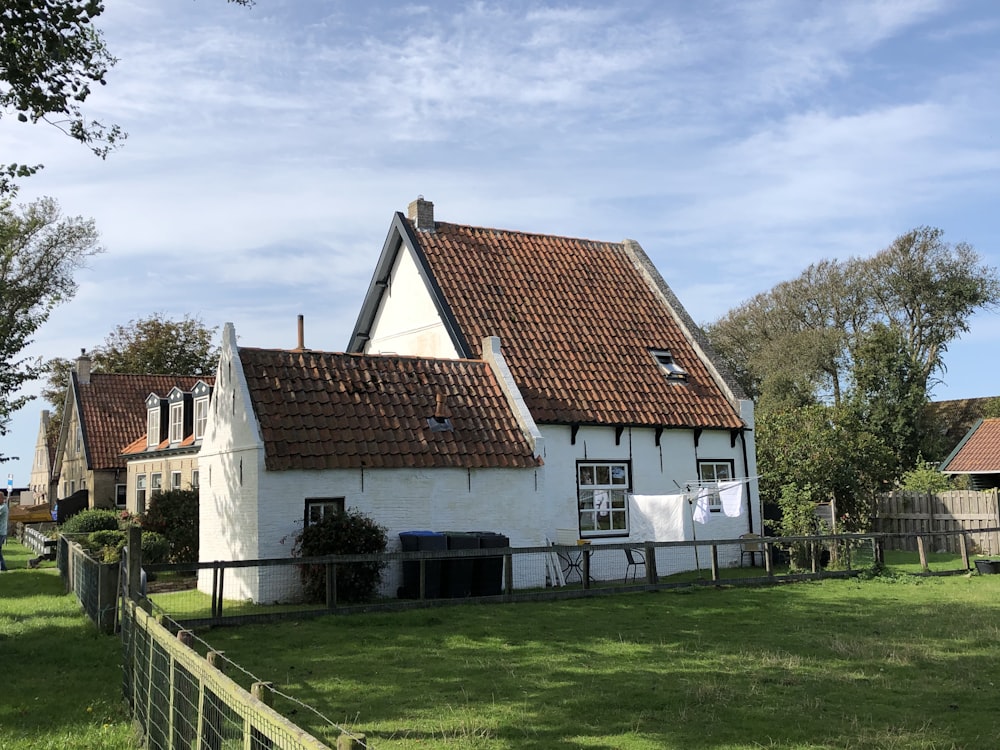 white and brown concrete house under white clouds during daytime