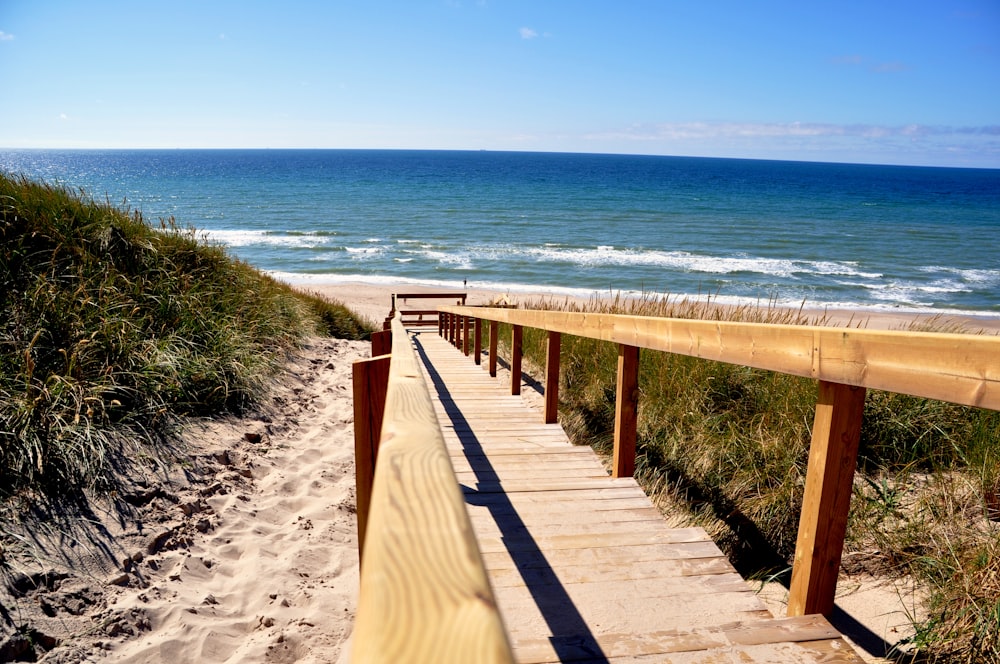 braune Holzbrücke am Strand tagsüber