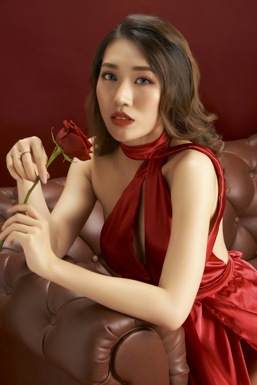 woman in red tank top holding red rose