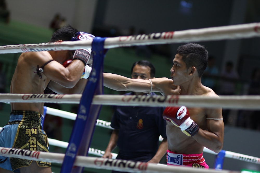 man in black and red jersey shirt holding red and white boxing gloves