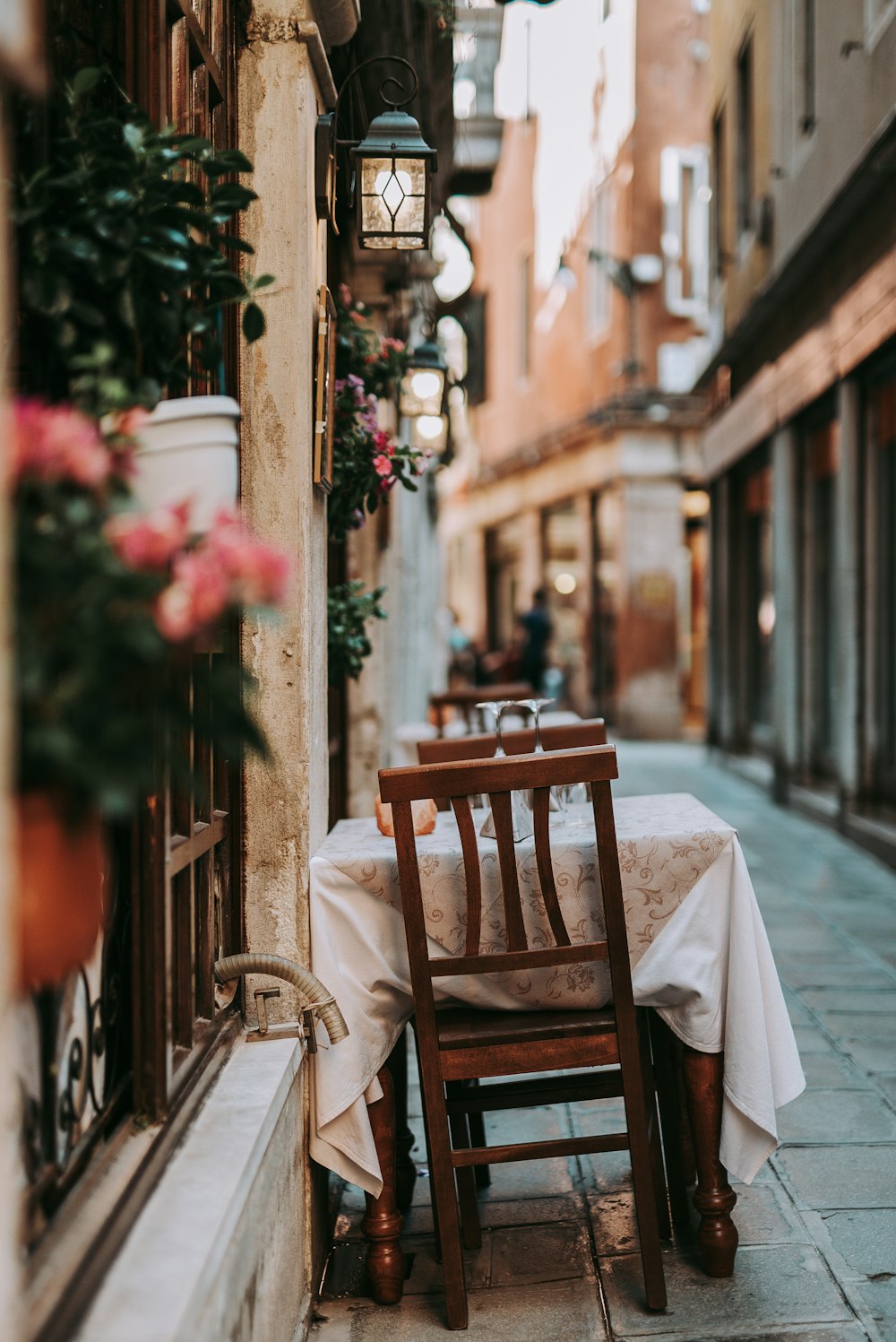 brown wooden chair beside red flowers