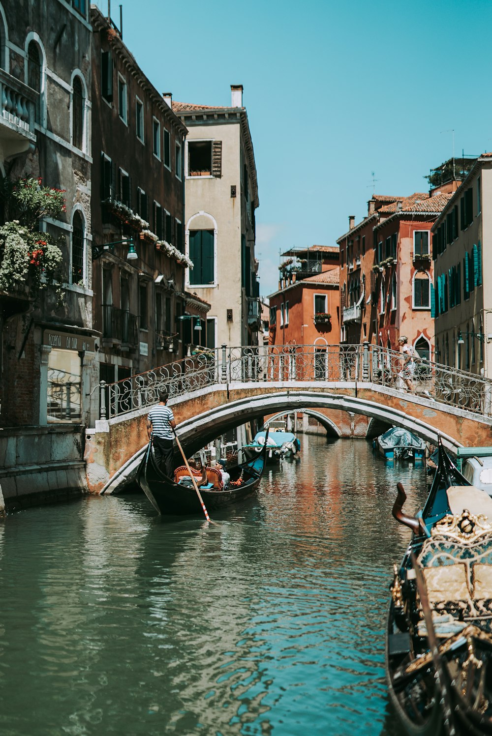 people riding on boat on river between concrete buildings during daytime