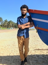 A friendly staff member smiling beside a colorful Bali watersport activity boat at the beach.