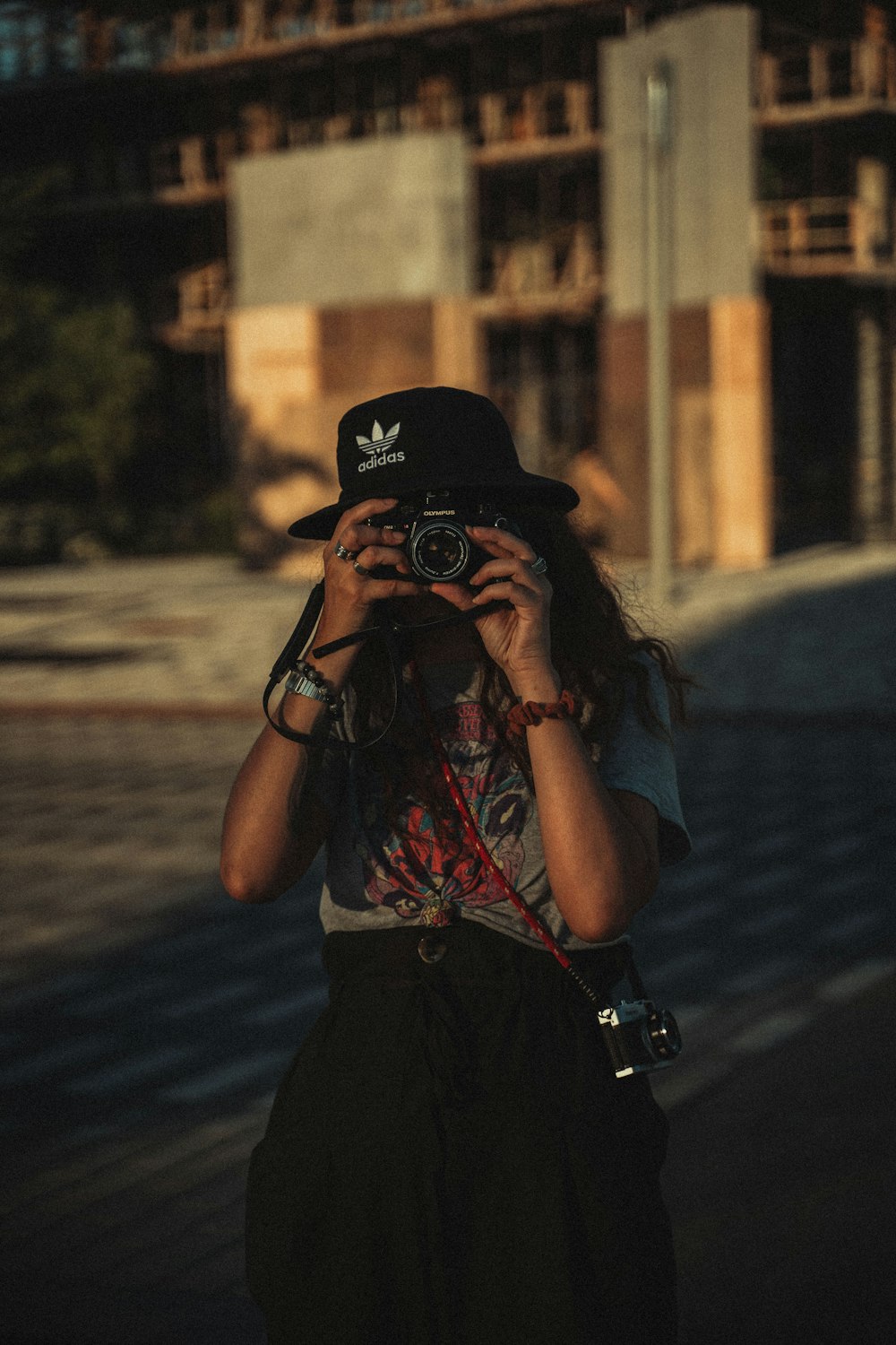 Donna in maglietta nera che tiene la fotocamera reflex digitale Nikon nera