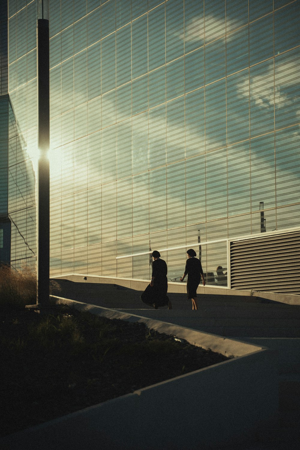 man in black jacket walking on sidewalk during daytime