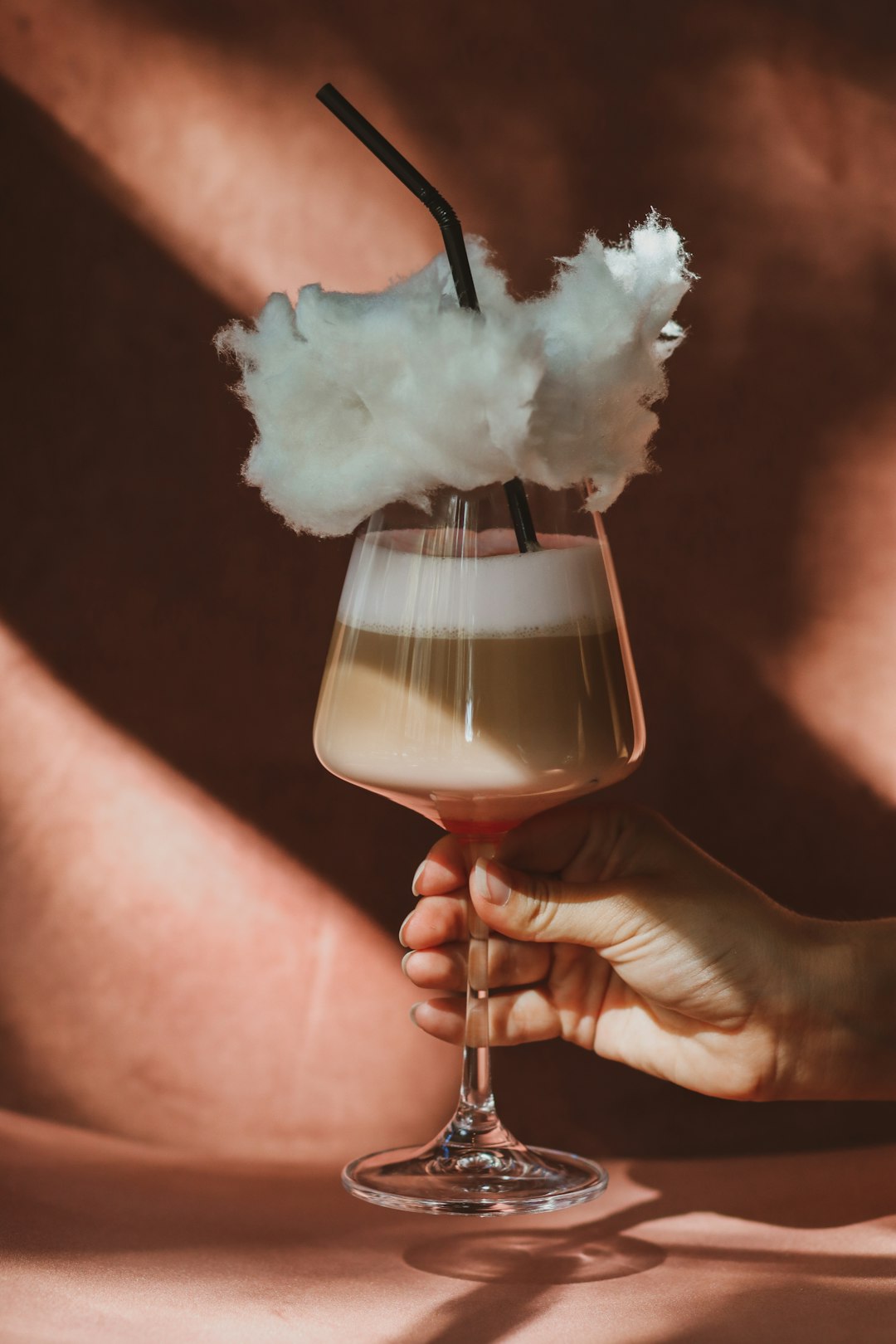 person holding clear wine glass with white smoke