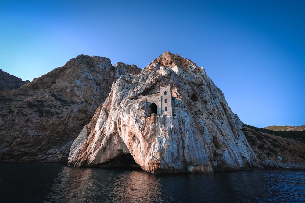 brown rock formation beside body of water during daytime