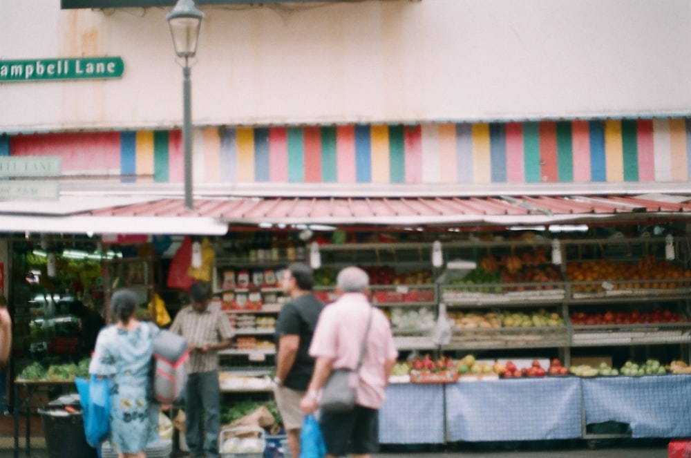 man in white t-shirt standing near food stall