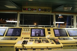 Close-up of advanced maritime navigation equipment glowing with data on a ship bridge.