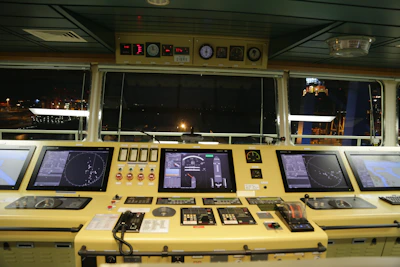 Close-up of a modern ship bridge with digital navigation screens glowing softly, highlighting advanced maritime technology.