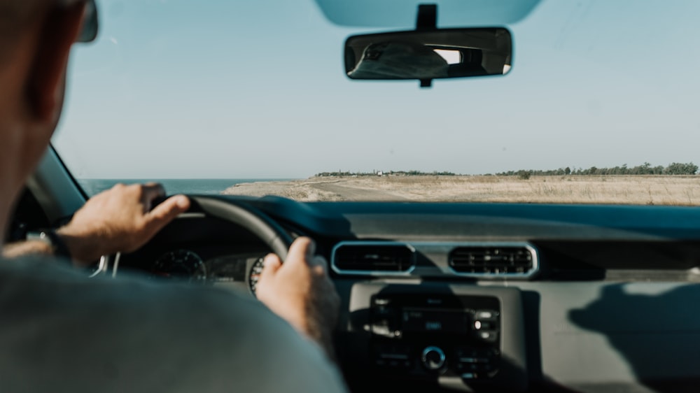 person driving car on road during daytime