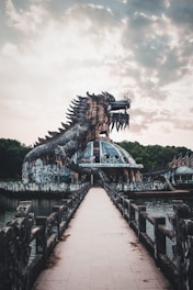 brown dragon statue near body of water during daytime
