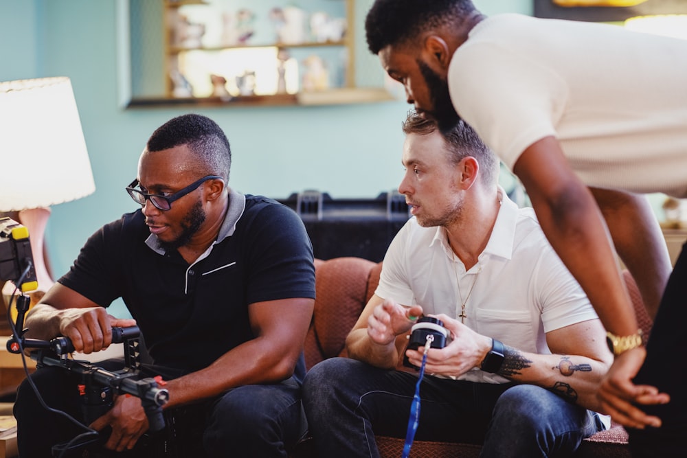 man in black polo shirt sitting beside man in white polo shirt