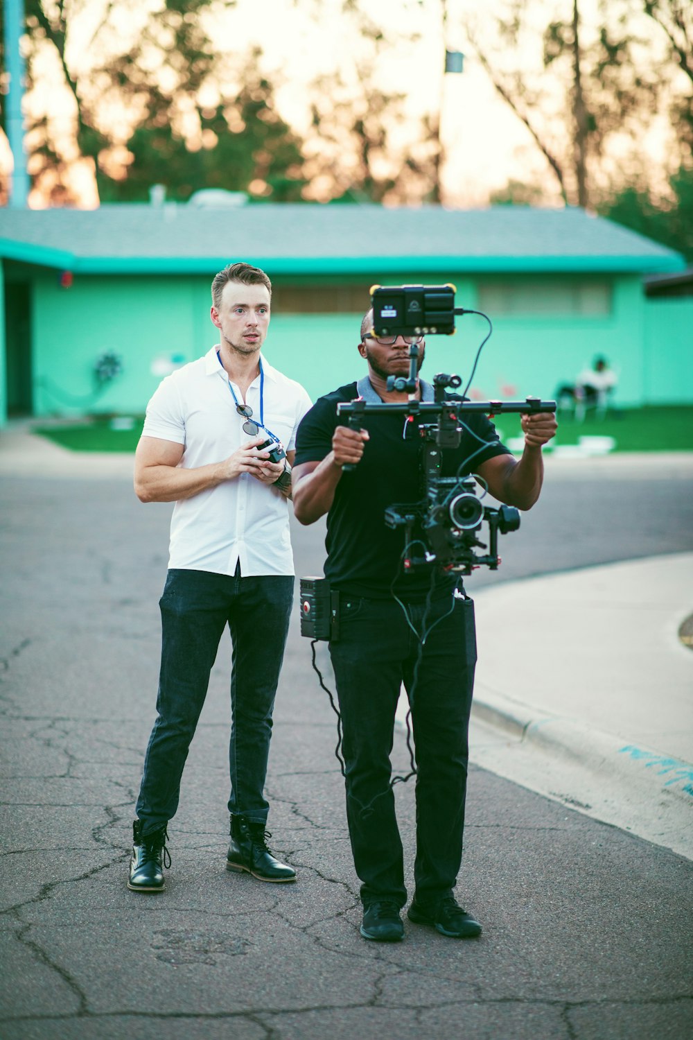 man in white dress shirt holding black camera