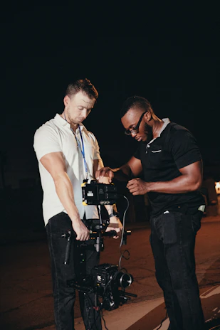 Creative team collaborating late at night surrounded by professional video and sound equipment.