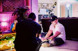 A mentor guiding a young person through a creative project in a bright room.
