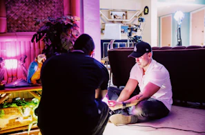 A mentor guiding a young person through a creative project in a bright room.