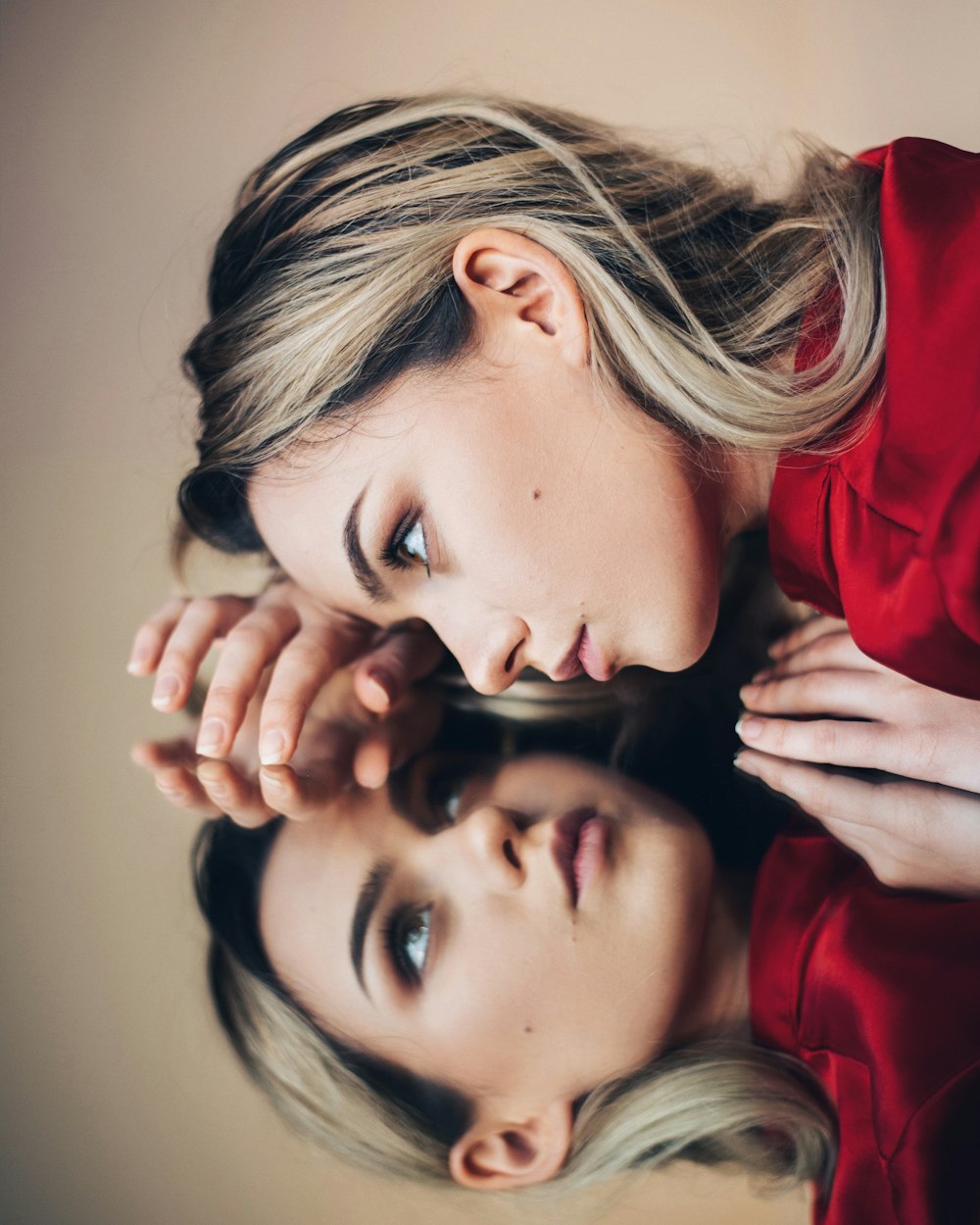 woman in red long sleeve shirt holding her face