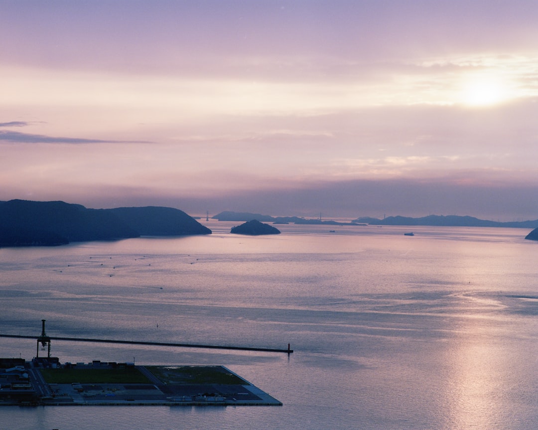 body of water near mountain during daytime