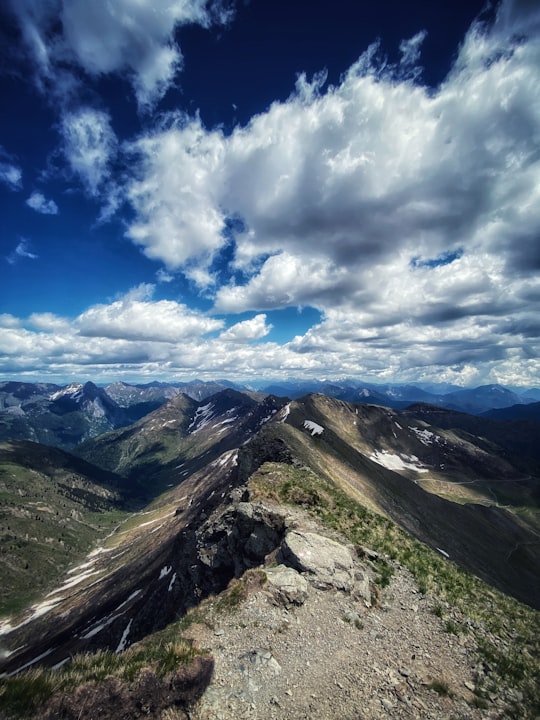 green and brown mountains under blue sky and white clouds during daytime in Monte Crostis Italy