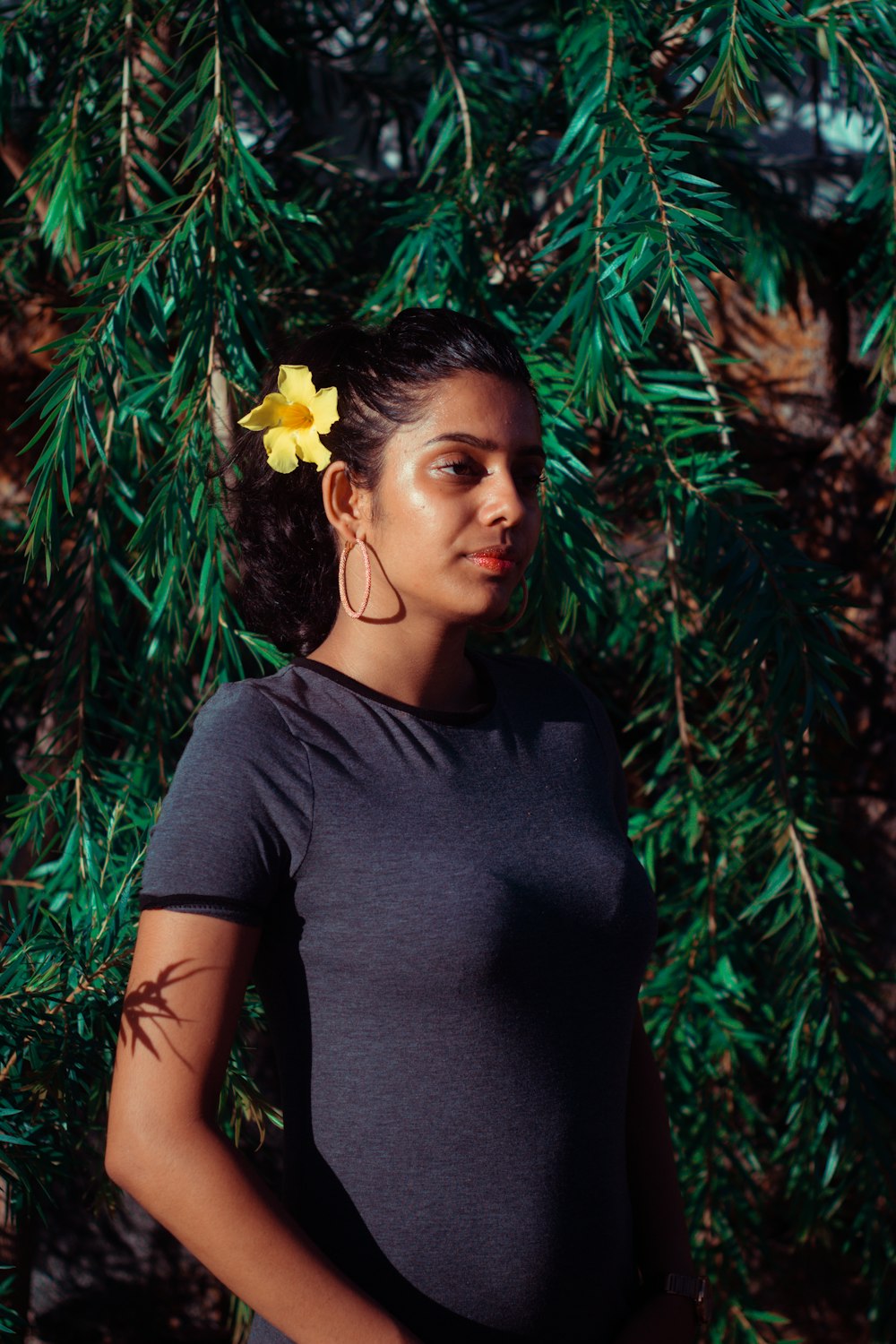 woman in black crew neck t-shirt standing near green leaves