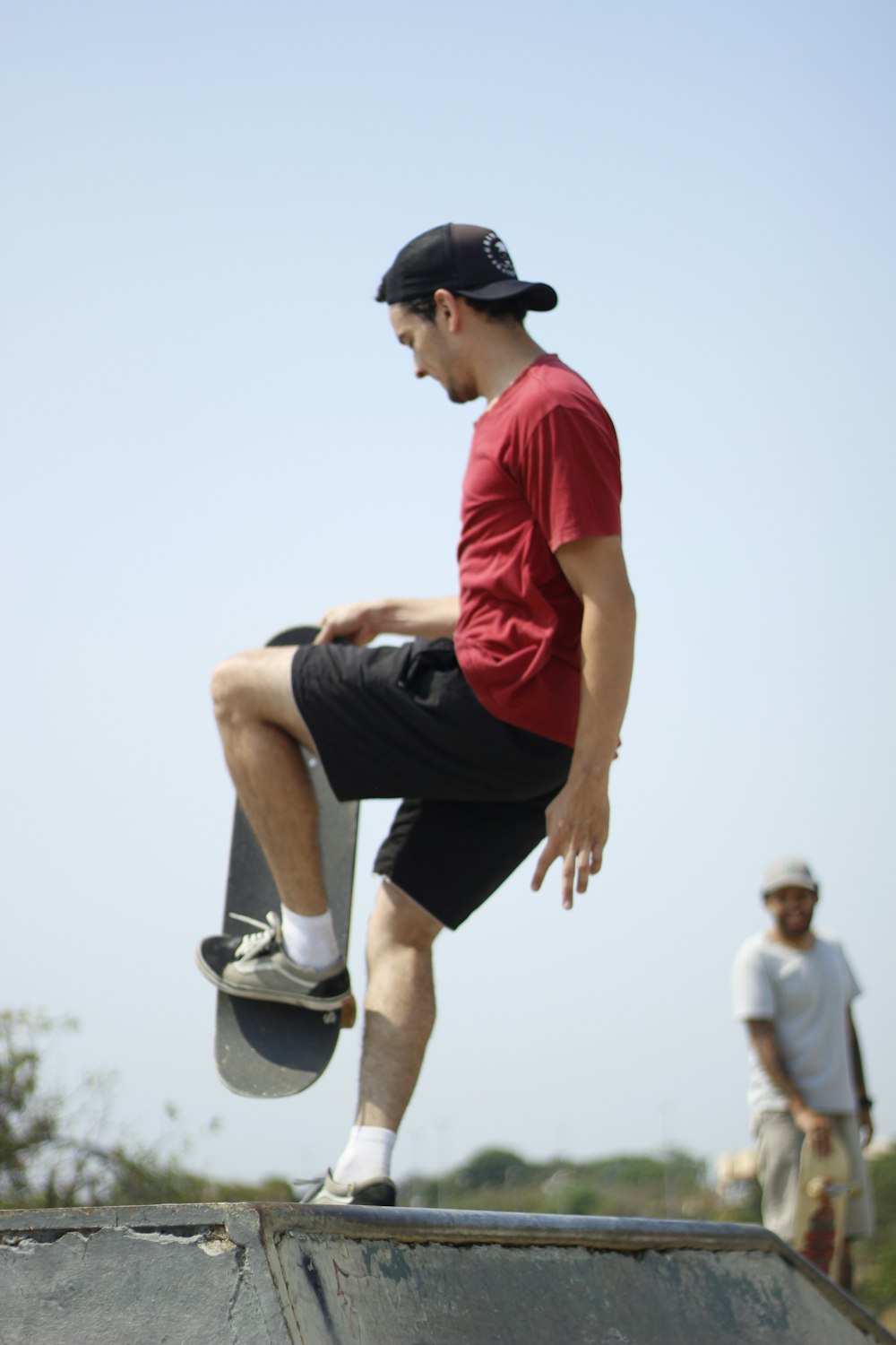 man in orange t-shirt and black shorts running on field during daytime