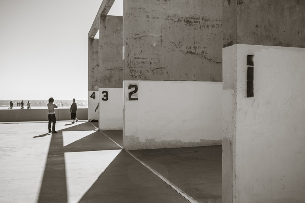 people sitting on bench near white wall during daytime