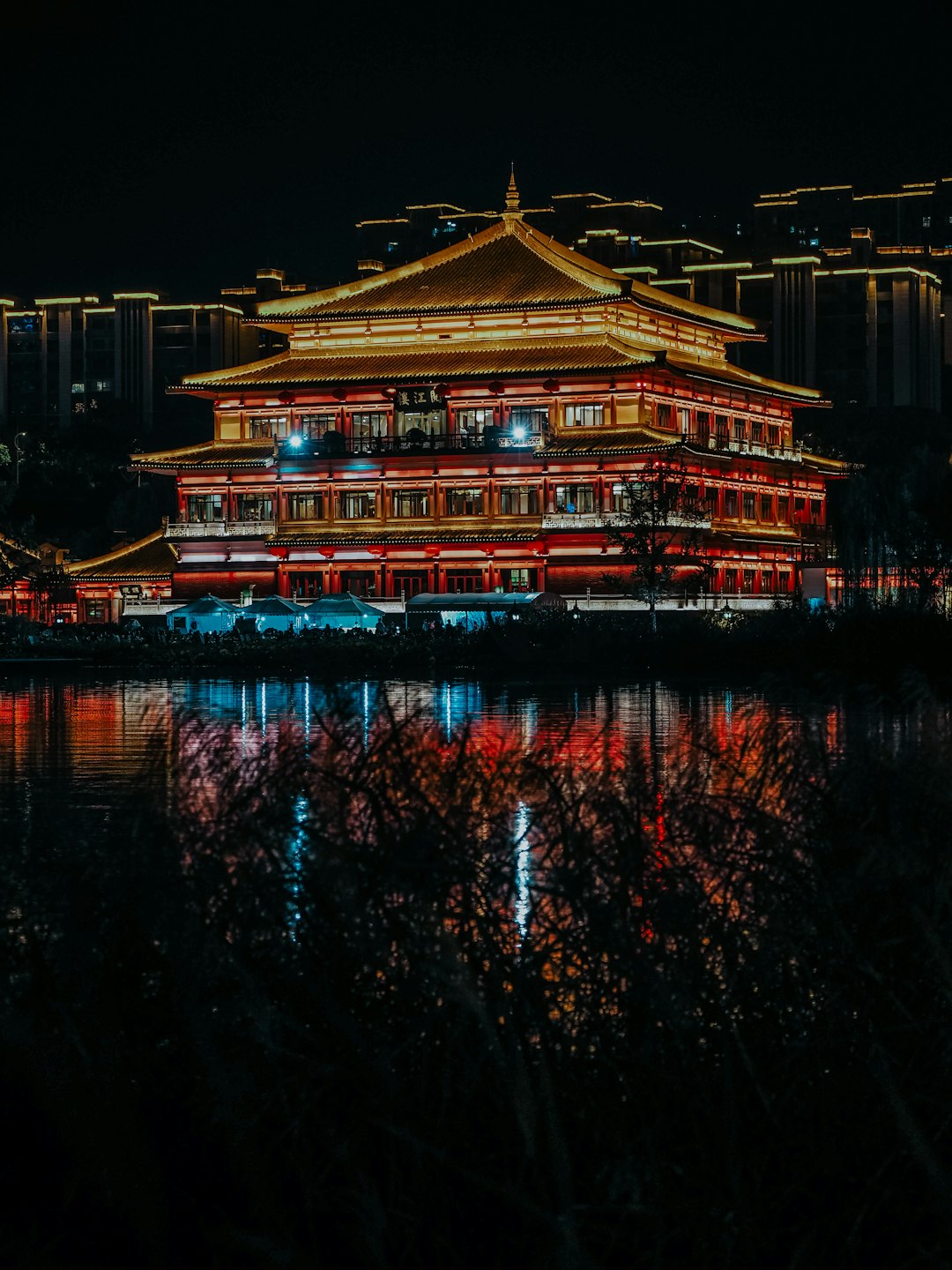 brown and white temple near body of water during night time