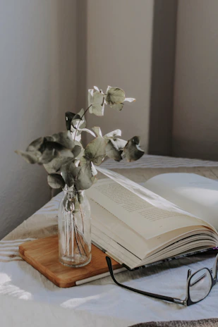A cozy scene with an open book about sacred plants surrounded by fresh herbs.