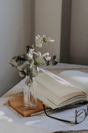An inviting scene of a morning ritual with an elycents perfume bottle, a cup of tea, and a slow-living book.