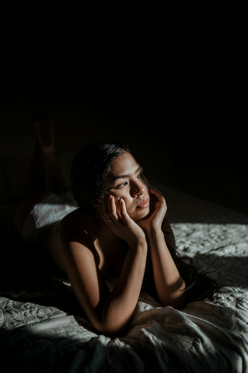 woman in black tank top lying on bed