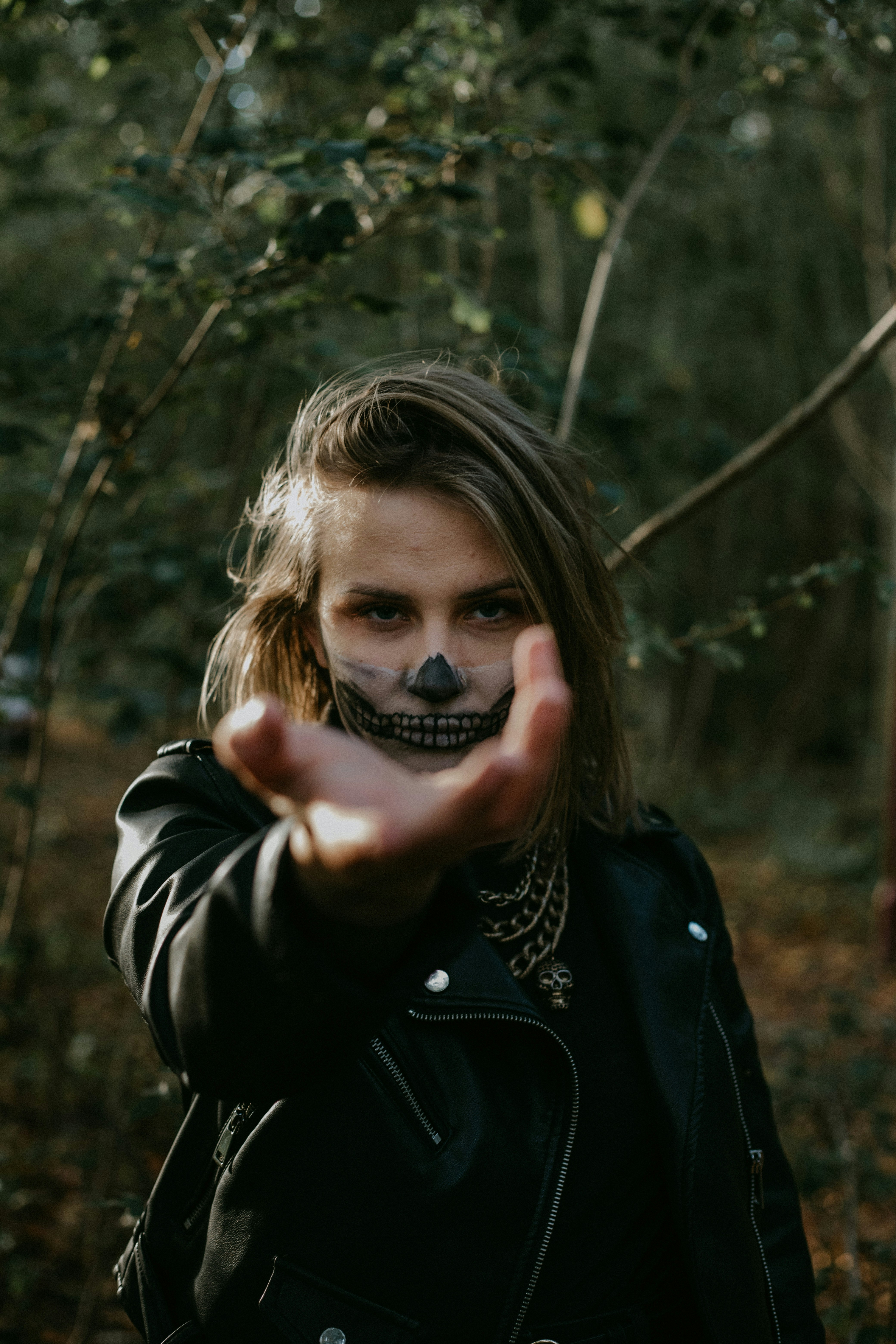 woman in black leather jacket holding her face